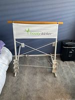 Booty Kicker ballet barre foldable frame with wooden rail, white metal and fabric panel.