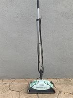 Front view of upright Eureka Enviro Steamer wooden floor steam cleaner with handle and cord wrapped around.