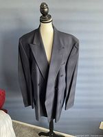 Front view of the blue pinstriped Kenneth Cole double-breasted suit jacket on a dress form.