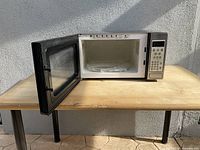 Microwave oven with door open showing interior and turntable