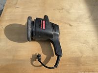 Handheld Craftsman electric sander on a wooden surface showing front and side views.