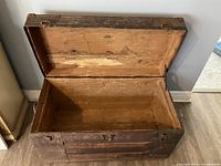 View of open wooden trunk showing interior and hinged lid