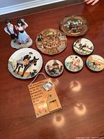 Photo of Italian themed decorative items including ceramic plaques, figurine of a couple, and wooden plaque with Italian writing on a wooden surface.