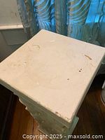 Top view of ceramic pedestal showing the square flat surface with nicks and scratches.
