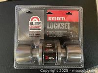 Front view of the packaged Elite Security keyed entry lockset with satin nickel exterior knob and branding showing.