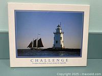 Front of the plaque showing lighthouse and sailing ship photo with caption 'CHALLENGE. To achieve the possible, we must attempt the impossible.'