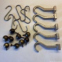 Collection of 5 J.K. Adams metal hooks, 7 round bronze drawer pulls with screws, and 7 metal S-shaped hooks