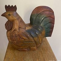 Front and side views of the hand carved wooden rooster showing paint details on tail and body, as well as close-up of the head and eye features.