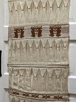 Close-up shot showing detailed texture of the woven cotton with triangular and geometric cinnamon brown patterns in fringe areas.