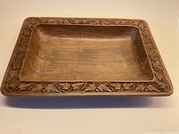 Top angle view showing the rectangular bowl with carved leafy rim and smooth interior surface