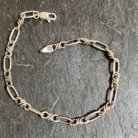 Full view of vintage handmade sterling silver Italian bracelet on dark stone surface.
