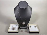 Complete view of the two matched sets, showing pendants and earrings separately and necklace on bust.