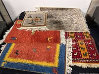 Overview of five rugs overlapping on table