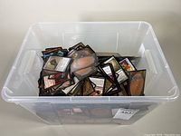 Plastic storage bin with loose Magic: The Gathering cards inside, visible card backs.