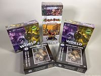 Photo showing two identical boxes of the Vintage Hockey Gloves 1000-piece jigsaw puzzles and three sealed board games: Its a Wonderful World, Its a Wonderful World Corruption & Ascension Expansion, and The Worshippers of Nivi Clash of Rage.