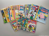 Full spread of assortment of vintage comic books arranged on a surface, showing various titles including Richie Rich Fortunes and Archie Comics.
