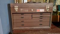 Closed brown Craftsman metal toolbox with visible latches and handle.