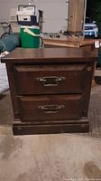 Front view of dark wood end table nightstand showing two drawers with metal handles