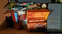 Garage drawer viewed from the top showing all included items in the drawer such as tools, stakes, an orange toolbox with bits, and a box of staples.