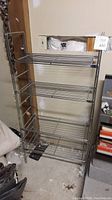 Metal wire shelving unit showing overall structure, with four wire rack shelves and metal rod frame.