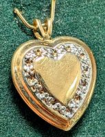 Close-up front view of the 10K yellow gold heart pendant showing detailed border and polished center.