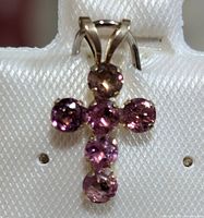 Front view of 10K gold cross pendant with purple tourmaline stones showing the faceted gems and gold setting.