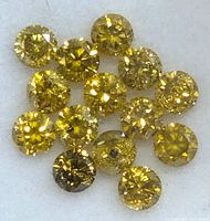 Close-up of loose yellow lab created round brilliant cut diamonds.