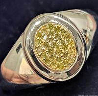 Close-up image of the front oval diamond cluster inlaid on the silver ring showing the detail of the diamonds and metal work.