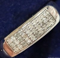 Close-up image showing the front view of the silver ring with multiple small diamonds set in rows on top, highlighting the diamond cluster design.