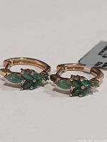 Front angle close-up of the pair of silver emerald earrings showing the marquise emerald stones and their setting.