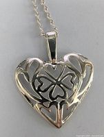 Close-up view of the heart-shaped pendant showing the four-leaf clover cutout design.