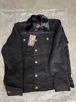 Full view of black jacket with plush collar laid flat, showing button closure and two chest pockets with buttons.