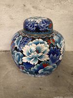 Front view of decorative vase showing detailed floral pattern in blue, white, and red.