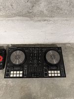 Wide shot of Native Instruments Traktor Kontrol S2 DJ controller showing dual jog wheels, buttons, faders, and performance pads.