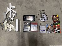 Multiple items laid out including Wii accessories, console, SNES mini, controller, GamePad, and games