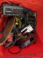 Overhead view of bin showing jump starter, leather belt, drill, staple gun and hooks