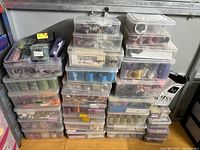 Photo showing a large stack of clear plastic storage containers holding many bangles of different colors and styles.