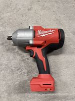 Left side profile of the red and black impact wrench on concrete floor