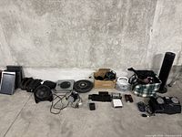 Wide view of entire lot showing all miscellaneous electronics on concrete floor.