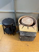 Pottery wheel in yellow splash pan next to black rolling stool