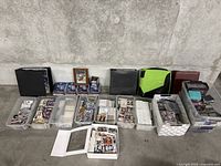 Overview of lot showing binders, tins, tubs and framed card