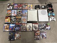 Overall top-down view of PS2/PS3 game cases, consoles, controllers and adapter
