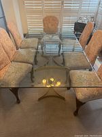 Full view of rectangular glass tabletop on metal and acrylic base with surrounding chairs