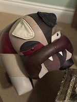 Front three-quarter view showing bulldog head, ears, eyes and stitched teeth