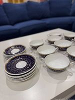 Eight soup bowls and eight saucers arranged on table