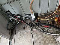 Photo of the 12 speed Super Cycle bicycle showing entire bike from an angled top view including seat, pedals, tires, brakes, and handlebars in a shed.