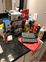 Photo of bathroom personal care items and boxed products on black granite countertop