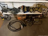Shelf with various Black and Decker power tools and extension cord shown.