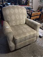 Front and angled views of a beige patterned manual recliner armchair highlighting the fabric condition and overall structure.