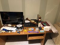 Desk with 27 inch Insignia monitor, HP Envy 4502 printer/scanner, barometer, wall clock, binder, pens, scissors, papers and other small office supplies.